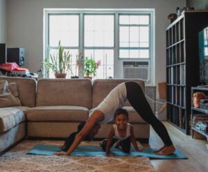 mom and daughter doing downward dog yoga pose
